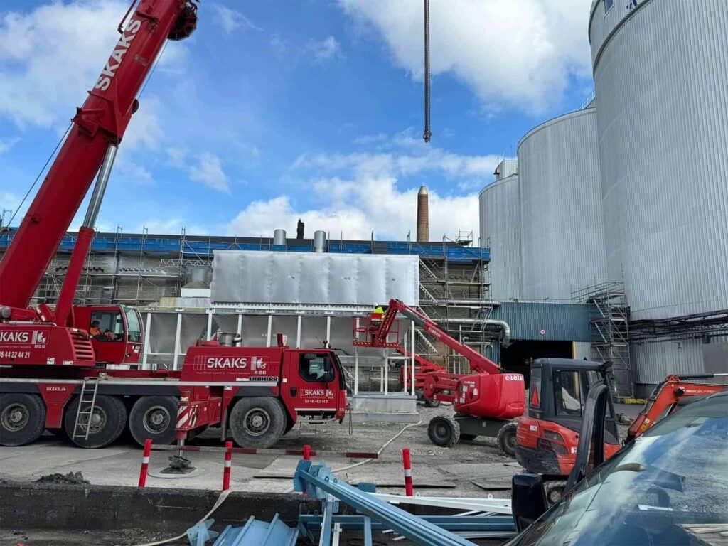 Mobilkran løfter et ventilationsanlæg på plads ved industrisiloer