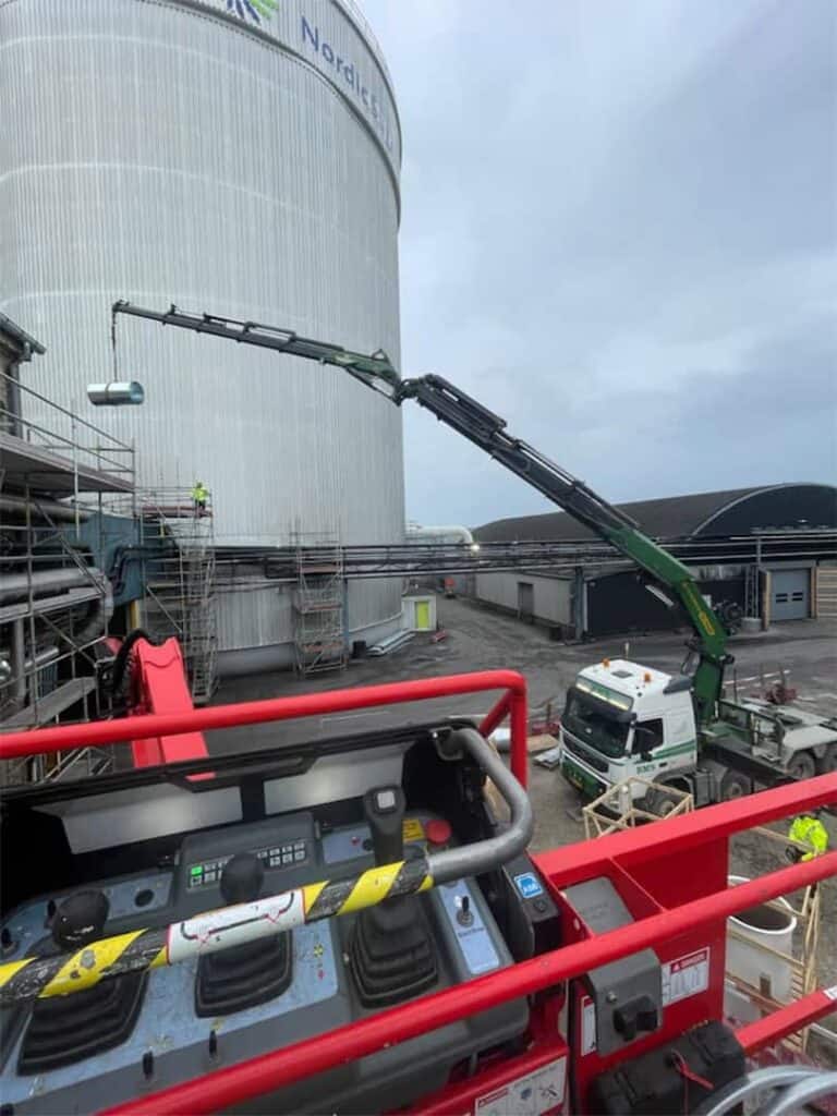 Kranarbejde med ventilationskanaler ved en industritank