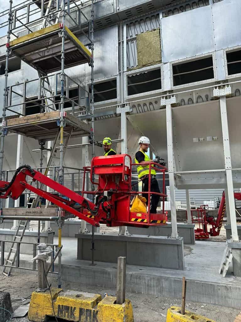 Montører arbejder fra lift på et industrielt ventilationsanlæg