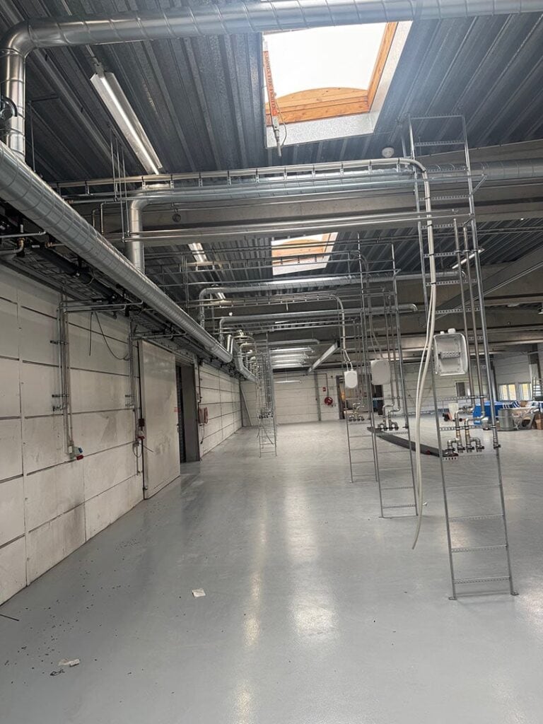 Ventilationsrør og montagestiger i en ny produktionshal