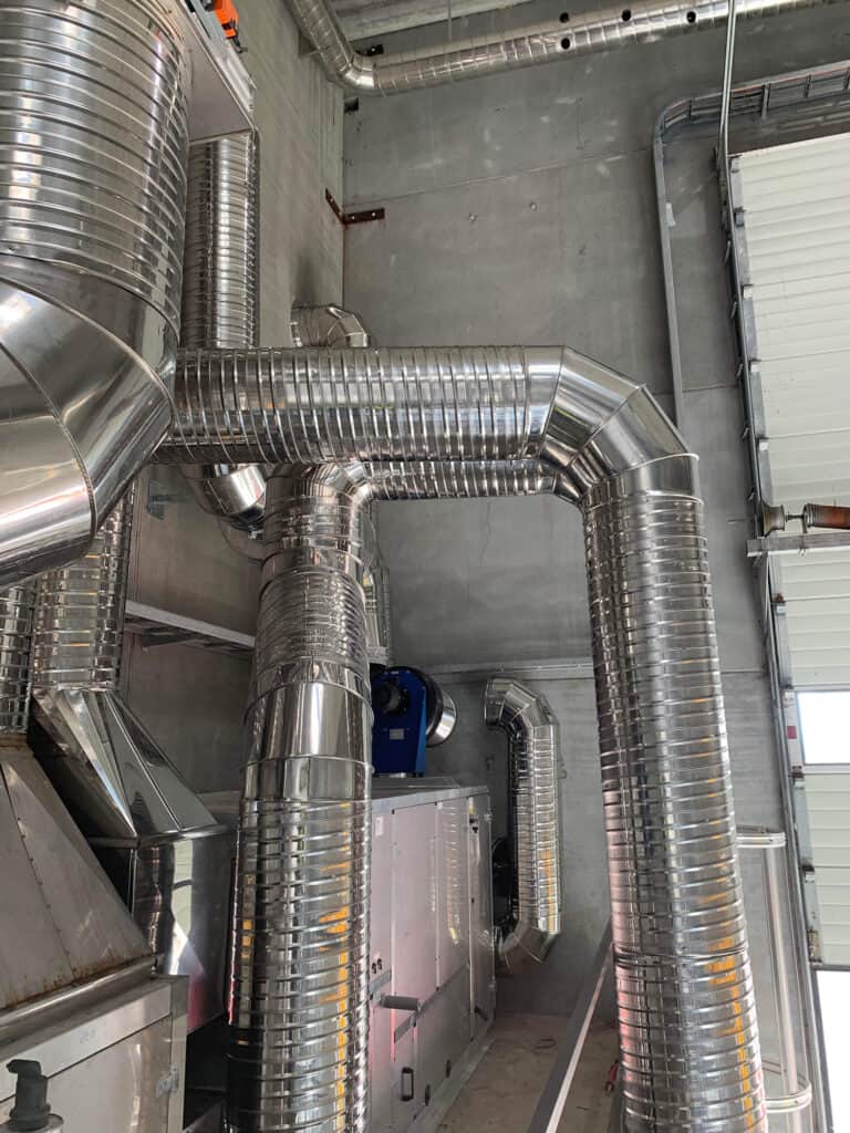 Blanke ventilationskanaler monteret i et teknikrum