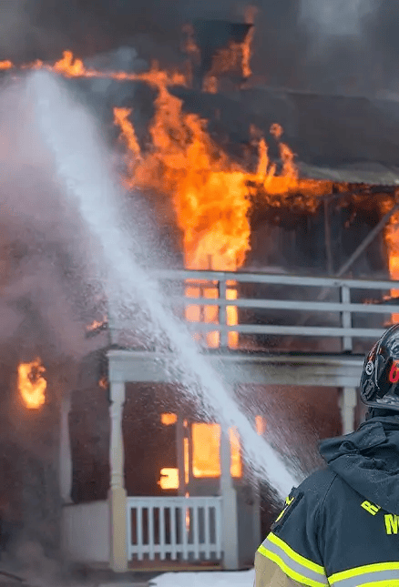 Brandmand slukker en brand i et hus - passiv brandsikring begrænser spredningen